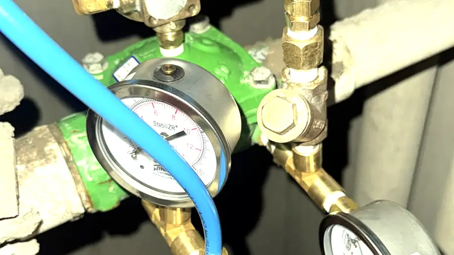 Manómetros con mangueras conectados a la válvula para verificar la calibración