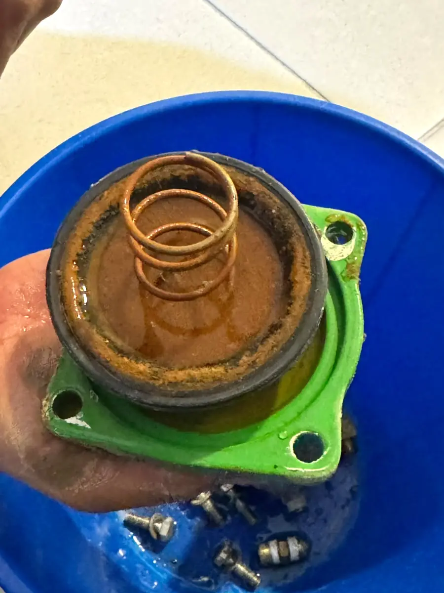 Tapa de la válvula desmontada con el resorte corroído y la cámara del diafragma oxidada
