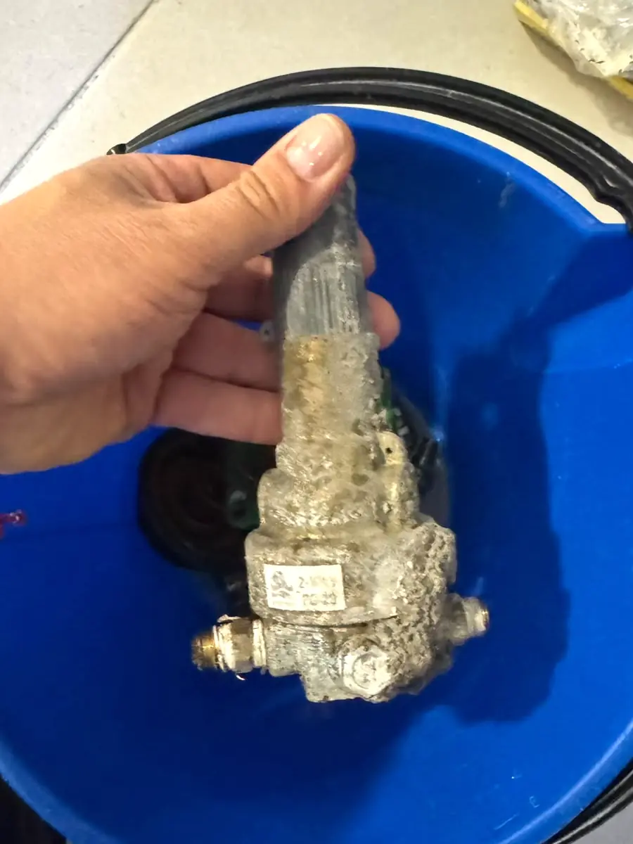 Vástago de una válvula reductora cubierto de incrustación mineral, durante un mantenimiento